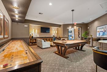 A billiards room with a pool table and a foosball table.